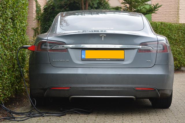 rear of grey Tesla Model 3 charging outside
